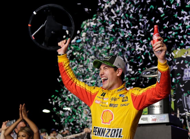 Joey Logano waves his steering wheel as confetti flies after winning the NASCAR Cup Series Championship auto race at the Homestead-Miami Speedway on Sunday evening. [TERRY RENNA/THE ASSOCIATED PRESS]