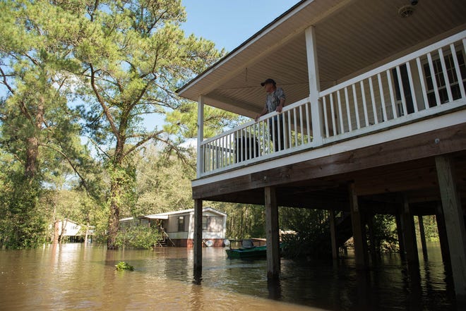 Mitch Townsend stands on the porch of his home as floodwaters from Little Swift Creek rise after Hurricane Matthew on Oct. 10, 2016. President Trump is considering changes to the national flood insurance program. [SUN JOURNAL FILE PHOTO]