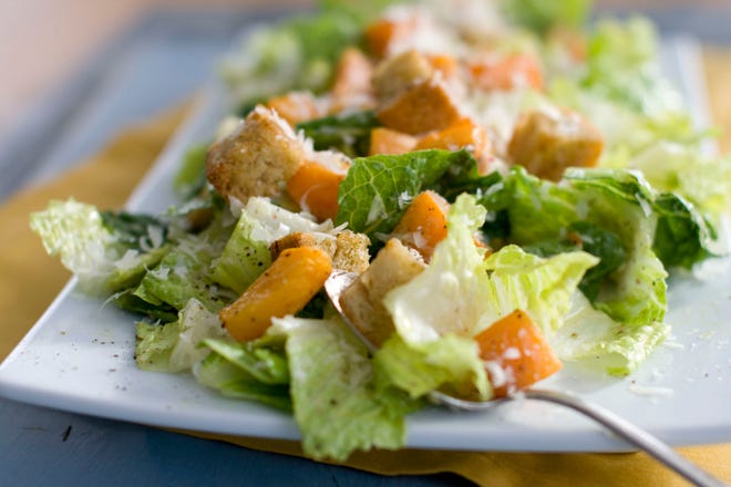 This file photo shows a Caesar salad with romaine lettuce. Food regulators are urging Americans not to eat any romaine lettuce because of a new food poisoning outbreak. The FDA says it's investigating an E. coli outbreak that has sickened over two dozen people in several states. [AP Photo/Matthew Mead, File]