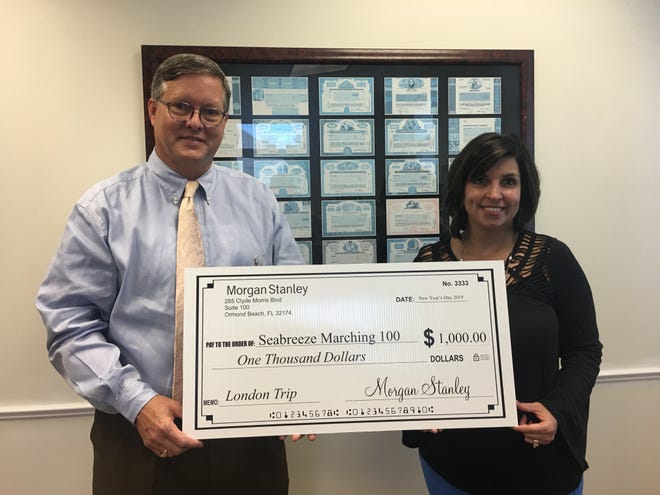 Jennifer Richardson and Paul Strong, financial advisors at Morgan Stanley, support the Seabreeze Marching 100 Band get to London on New Year's Day with a $1,000 contribution. [Photo provided]