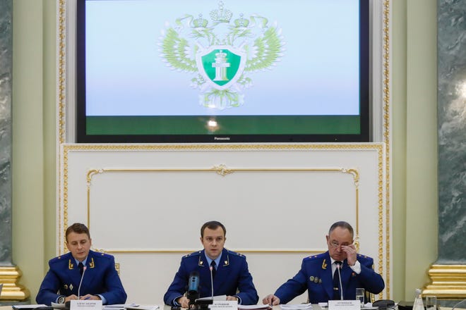 From left, an aide to the Russian Prosecutor General Mikhail Alexandrov, Russian Prosecutor General spokesman Alexander Kurennoi, and an aide to the Russian Prosecutor General Nikolai Atmoniev attend a news conference in Moscow, Russia, Monday, Nov. 19, 2018. Russian prosecutors on Monday announced new charges against Bill Browder, accusing him of forming a criminal group to embezzle funds in Russia. They also said they suspect Magnitsky's death in prison was a poisoning and said they have a "theory" Browder is behind the poisoning. (AP Photo/Pavel Golovkin)