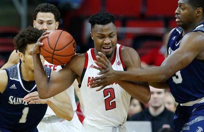 North Carolina State's Torin Dorn pulls in the rebound from Saint Peter's Samuel Idowu during the first half in Raleigh on Tuesday. [Ethan Hyman/The News & Observer via AP]