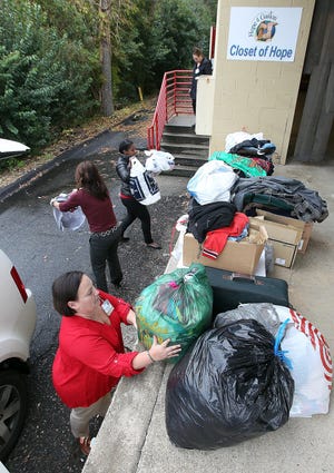 CaroMont employees Casey Morningstar, Jaime Smith, and Darcell Walker, unload some of the coats and other clothing they collected for Hope4Gaston. [JOHN CLARK/THE GASTON GAZETTE]
