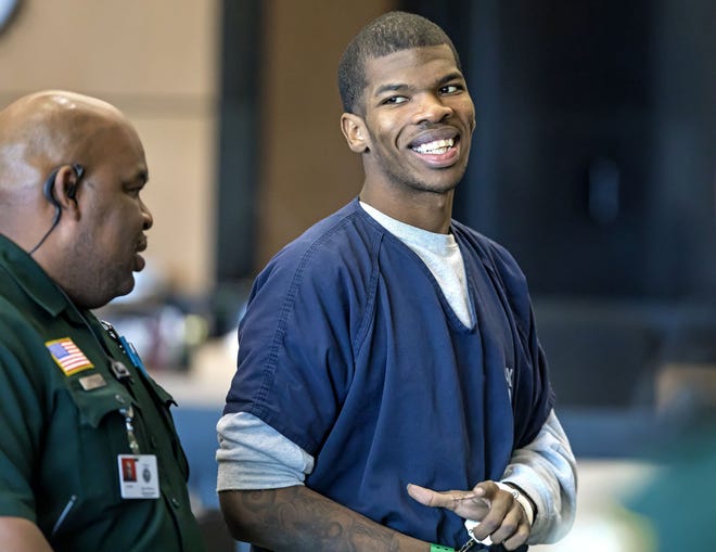 Kareen Kenneth Walker smiles at family members in the gallery as he is led from the courtroom after being resentenced by Circuit Judge John S. Kastrenakes Wednesday, November 21, 2018. He was sentenced to the same 40 years he originally got after his conviction for second-degree murder with a firearm. [LANNIS WATERS/palmbeachpost.com]