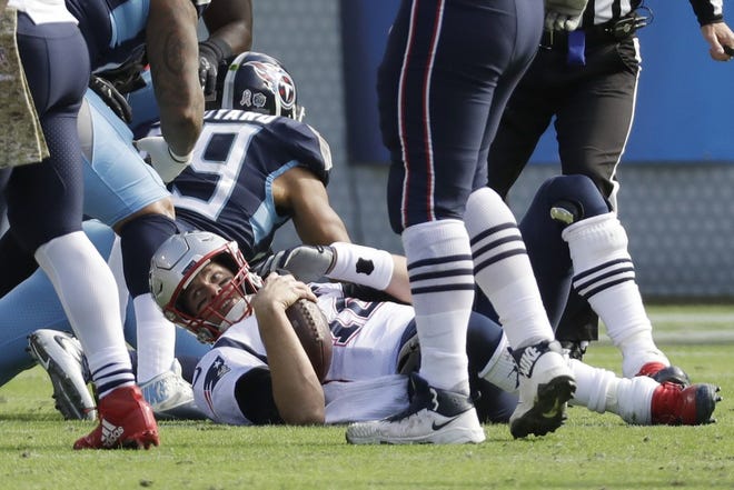 New England Patriots quarterback Tom Brady (12) lies on the ground after being sacked by the Tennessee Titans in the first half of an NFL football game Sunday, Nov. 11, 2018, in Nashville, Tenn.