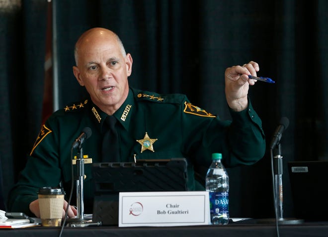 FILE- In this June 7, 2018 file photo Marjory Stoneman Douglas High School Public Safety Commission chair and Pinellas County Sheriff Bob Gualtieri gestures as he speaks during a commission meeting in Sunrise, Fla. Guiltieri says he now believes trained, volunteer teachers should have access to guns so they can stop shooters who get past other safeguards. (AP Photo/Wilfredo Lee, File)