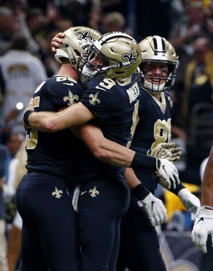 Saints quarterback Drew Brees (9) hugs tight end Dan Arnold (85) after the two connected on a touchdown reception in the second half of Thursday night's game against the Atlanta Falcons in New Orleans. [Butch Dill/AP]