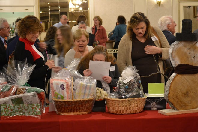 Guests look at some of the bids places on items at the Holiday Fund kickoff. [Herald News Photo | Will Richmond]