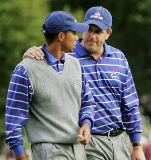 In this Sept. 17, 2004, photo, U.S. team player Phil Mickelson puts his arm around partner Tiger Woods as they walk off the 18th green after they lost to Europeans Darren Clarke and Lee Westwood on the final hole of their foursomes match at the 35th Ryder Cup at Oakland Hills Country Club in Bloomfield Township, Mich. They play a high-stakes exhibition Friday in Las Vegas in golf's first venture using pay-per-view. [AP PHOTO/DAVE MARTIN]