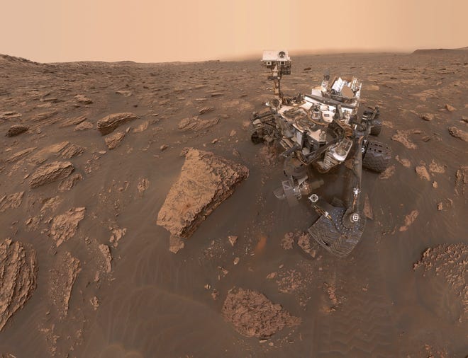 This composite image made from a series of June 15, 2018 photos shows a self-portrait of NASA's Curiosity Mars rover in the Gale Crater. The rover's arm which held the camera was positioned out of each of the dozens of shots which make up the mosaic. A dust storm has reduced sunlight and visibility at the rover's location. [NASA]