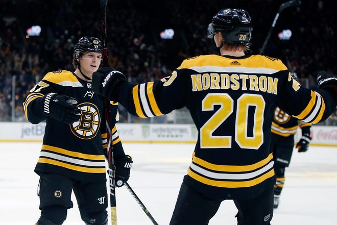 The Bruins' Joakim Nordstrom (20) celebrates his game-winning goal in overtime with Torey Krug.