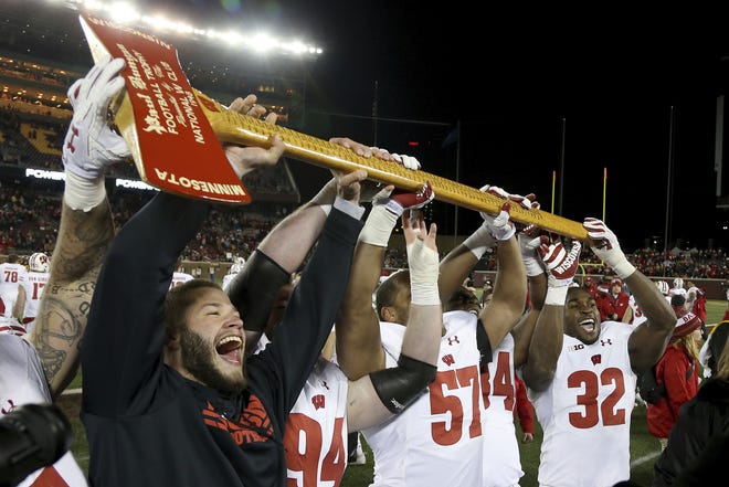 Wisconsin players hold up Paul Bunyan's Axe up after winning 31-0 against Minnesota in Minneapolis on Nov. 25, 2017. The Badgers and Golden Gophers will battle for the trophy on Saturday. [STACY BENGS/THE ASSOCIATED PRESS]