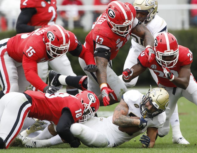 The Georgia defense takes down Georgia Tech A-Back Nathan Cottrell (31) during the first half of the Bulldogs' regular-season ending victory Saturday. [Photo/Joshua L. Jones, Athens Banner-Herald]