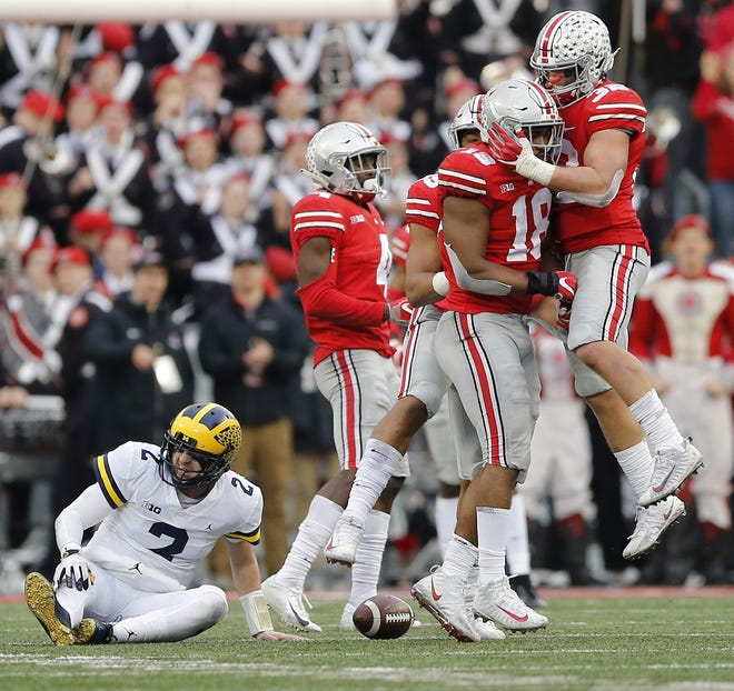Ohio State defensive end Jonathon Cooper, middle, celebrates with teammates after sacking Michigan's Shea Patterson, left. Cooper's sack was negated by a facemask penalty, however, and Patterson left the game after being injured on the play. [Kyle Robertson/Dispatch]