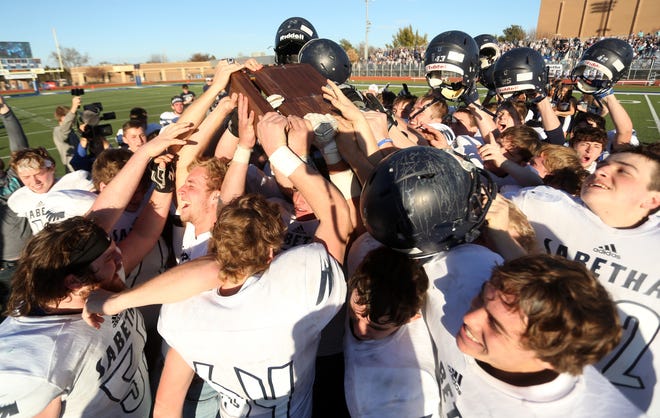 Sabetha players celebrate with the Class 3A championship trophy Saturday after their 43-42 overtime win against Pratt in Hutchinson. The title was the second in a row for Sabetha. [TRAVIS MORISSE/SPECIAL TO THE CAPITAL-JOURNAL]