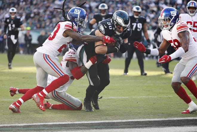 Eagles tight end Zach Ertz scores a touchdown late in the first half Sunday as New York Giants' B.W. Webb (23) Curtis Riley (35) and Tae Davis (58) try to stop him. Ertz led the team in receiving Sunday with seven catches for 91 yards. [CHRIS SZAGOLA / THE ASSOCIATED PRESS]