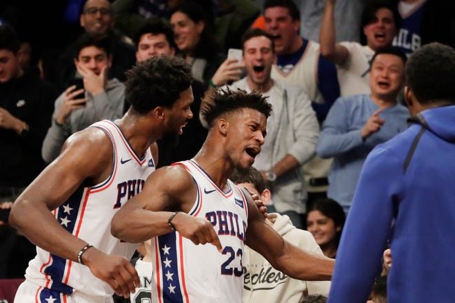 The Sixers' Joel Embiid, left, congratulates teammate Jimmy Butler after he sank a game-winning three-point shot against the Brooklyn Nets Sunday night. The 76ers won 127-125. [MARK LENNIHAN / THE ASSOCIATED PRESS]