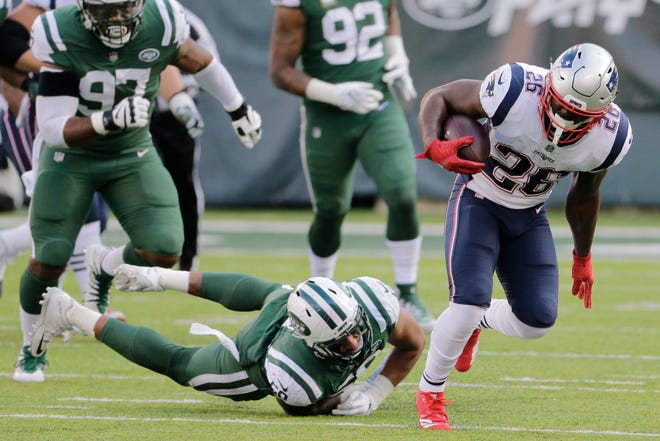 New England Patriots' Sony Michel (26) breaks a tackle by New York Jets' Frankie Luvu (50) during the second half of an NFL football game Sunday, Nov. 25, 2018, in East Rutherford, N.J. (AP Photo/Seth Wenig)