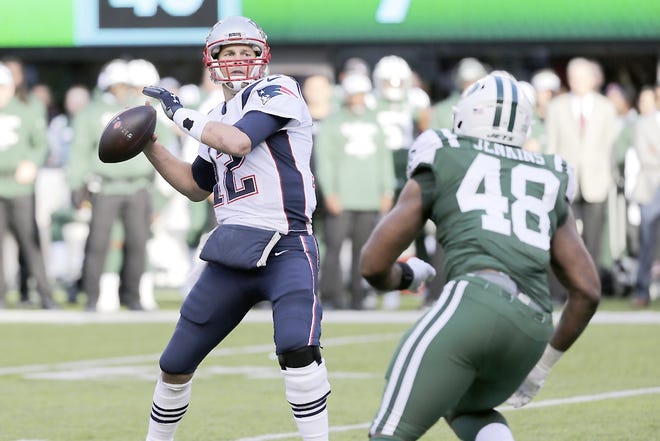 New England Patriot Tom Brady (12) throws a pass over New York Jet Jordan Jenkins during the first half of Sunday's game in East Rutherford, New Jersey.    

[Seth Wenig / Associated Press]