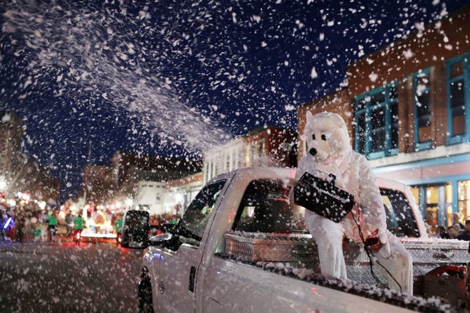 A polar bear in the back of a pickup truck pulling the Burlington Baptist Church float makes snow during the 25th annual Lighted Holiday Parade Saturday in downtown Burlington. Winter Wonderland was the theme of this years parade. [John Lovretta/thehawkeye.com]