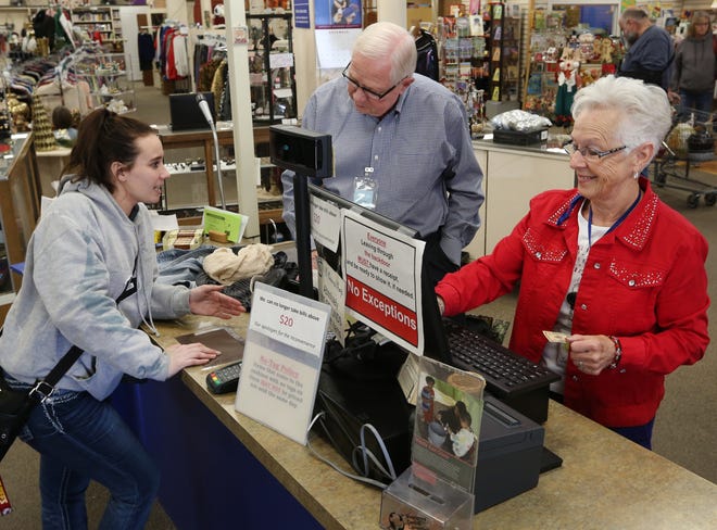 Taylor Bell pays for the items she is purchasing with help from Merlin Preheim, center, and Jane Kroeker, right, at the Et Cetera Shop Tuesday afternoon, Nov. 20, 2018. [Sandra J. Milburn/HutchNews]
