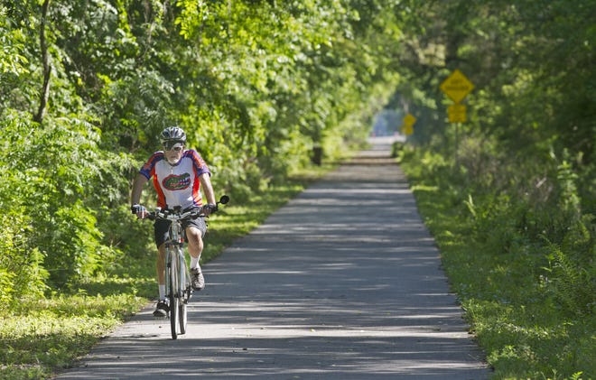 A bicyclist travels along a section of St. Johns River-to-Sea Loop that runs through the woods next to State Road 207, near Armstrong, The 7th Annual SEA Rails to Trails Bike Ride is planned for 9 a.m. Dec. 1. To reigster, go to registerSEA.com. [PETER WILLOTT/FILE PHOTO]