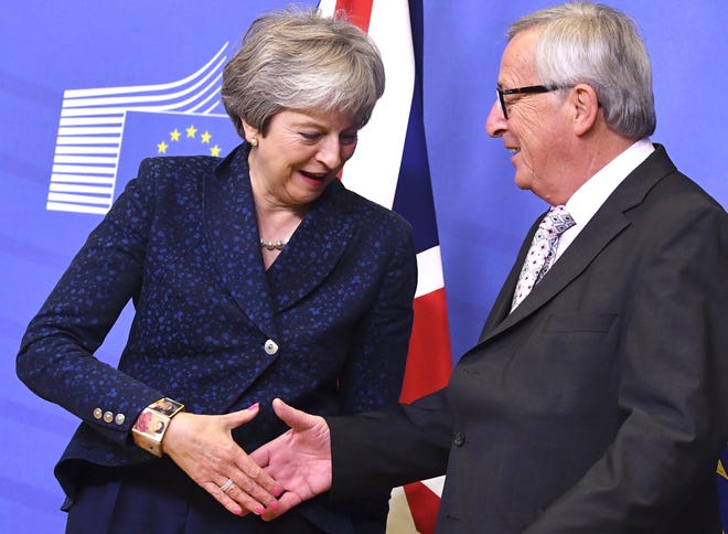 European Commission President Jean-Claude Juncker, right, shakes hands with British Prime Minister Theresa May prior to a meeting at EU headquarters in Brussels on Saturday, Nov. 24. [GEERT VANDEN WIJNGAERT/THE ASSOCIATED PRESS]