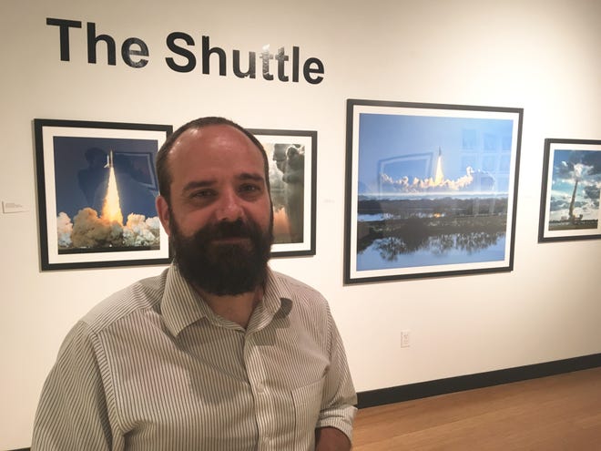 Southeast Museum of Photography Director James Pearson stands in front of photos of the space shuttle by John Chakeres. [News-Journal/Austin Fuller]