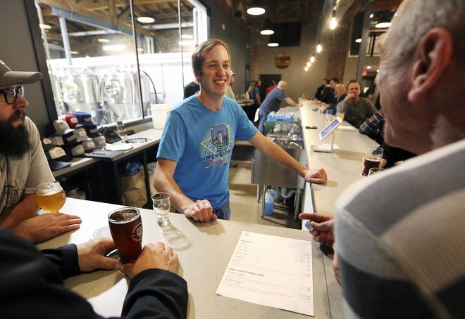 Bartender Patrick Hennessy takes a drink order at Dimensional Brewing Co. in Dubuque. [Nicki Kohl/Telegraph Herald]