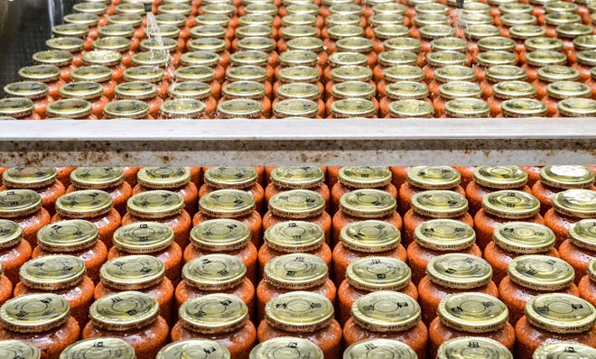 Jars of sauce are cooled before being labeled and packaged for distribution at Mid's Homestyle Pasta Sauce in Navarre. (CantonRep.com / Michael Balash)