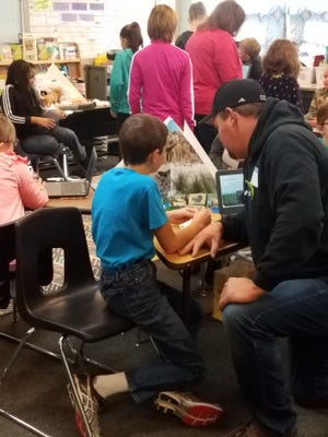 Fourth-graders at Pearl City Schools recently studied Native Americans. Pictured: Eli Bremmer presents his project as his dad, Chad Bremmer, listens. [PHOTO PROVIDED]