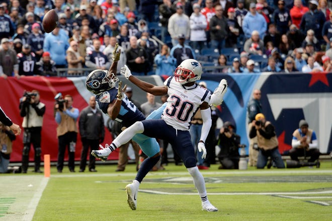 Tennessee Titans wide receiver Corey Davis (84) can't hang onto a pass as he is defended by New England Patriots cornerback Jason McCourty (30) in the first half of an NFL football game Sunday, Nov. 11, 2018, in Nashville, Tenn.