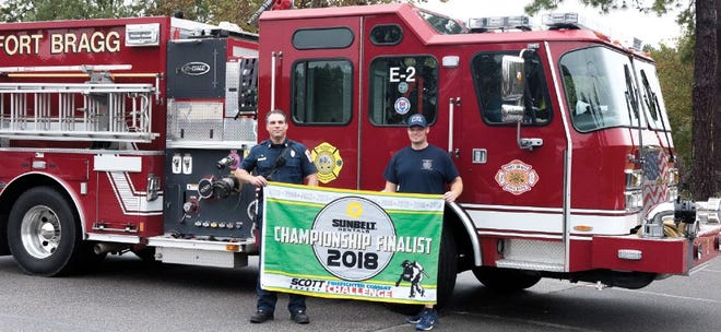 Fort Bragg firefighters Jaymon Hotz, Station Six, and Keith DiPaini, Station Two, hold up the sign of their achievement for making it to the final round of the 3M Scott Firefighter Combat Challenge in Virginia. The world challenge is the last level and was held in California.