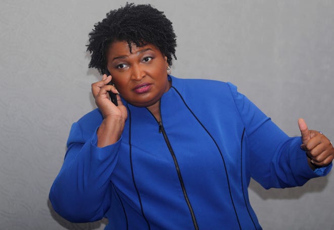 FILE - In this Aug. 3, 2018, file photo, Georgia gubernatorial candidate Stacey Abrams answers her phone before speaking at the National Association of Black Journalists in Detroit. Southern politics was a one-party affair for a long time. But now it’s a mixed bag with battlegrounds emerging in states with growing metro areas where white voters are more willing to back Democrats. (AP Photo/Carlos Osorio, File)