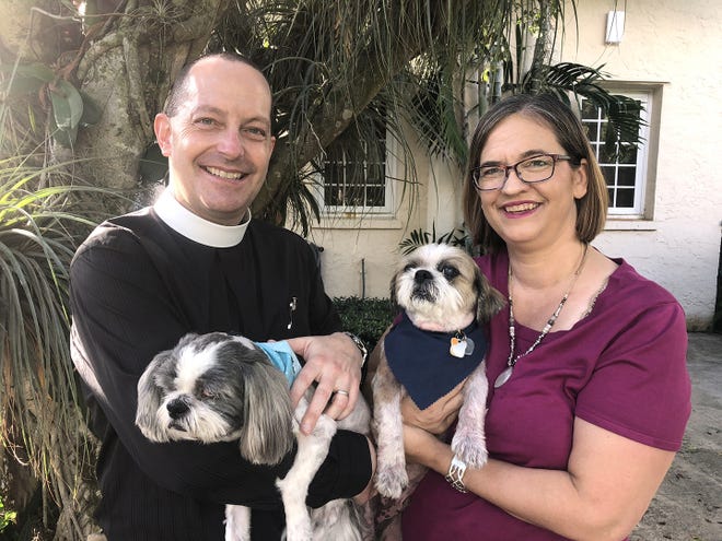 The Rev. James Harlan holds Chance, who they got from Peggy Adams, while Elizabeth Harlan holds Ranger, their first adopted dog. [Photo by Paul Noble]