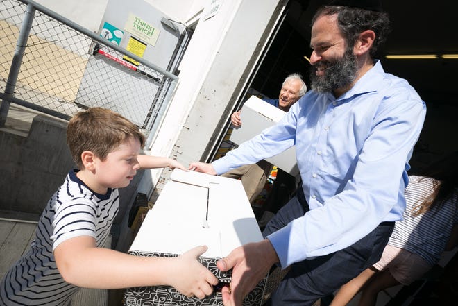 Palm Beach Synagogue volunteers donated and delivered 110 family boxes of Thanksgiving dinners. Rabbi Moshe Scheiner and helper Teddy Hames load a truck with the dinners Wednesday at Publix. The truck loaded at Publix was donated as well by the synagogue to True Fast Food Pantry. {Photo by Tom Tracy, courtesy of Palm Beach Synagogue]