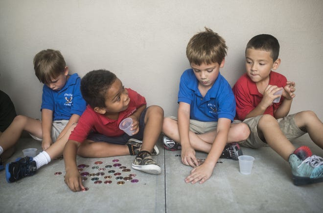 August Green, center right, and Dylan Sanchez, center left, count coins at Alta Vista's Eagle Academy summer program on June 25, 2015. [HERALD-TRIBUNE STAFF PHOTO / NICK ADAMS]