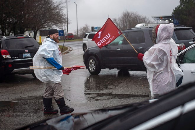 Members of Unifor, the union representing the workers of Oshawa's General Motors assembly plant, stand near the entrance to the plant in Oshawa, Ontario, Monday, Nov. 26, 2018. General Motors will lay off thousands of factory and white-collar workers in North America and put five plants up for possible closure as it restructures to cut costs and focus more on autonomous and electric vehicles. General Motors is closing the Oshawa plant. (Eduardo Lima/The Canadian Press via AP)