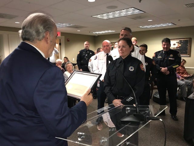 Mount Dora firefighter Dara Hennessey listens as Mayor Nick Girone reads a certificate of appreciation during a City Council meeting on Tuesday. [Submitted]