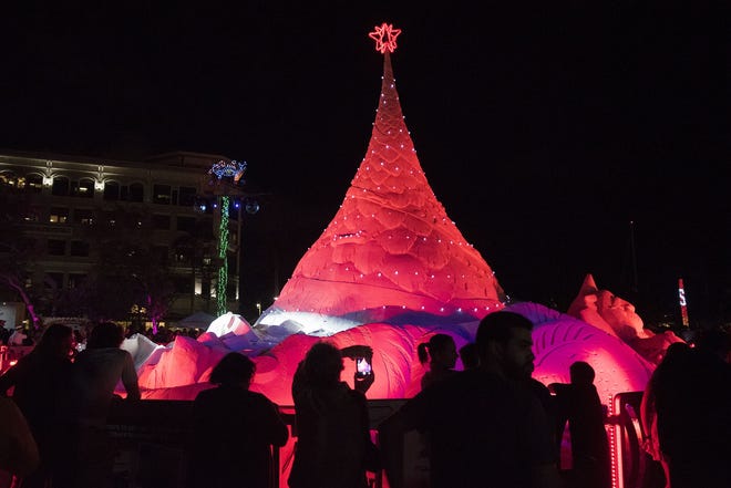 Hundreds of visitors watch and take photos of the lighting of Sandi the 600-ton sand Christmas tree in West Palm Beach in 2017. [Palm Beach Post file photo]