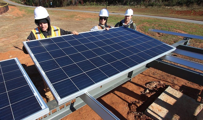 Sundance Power Systems installation crew members, from left, Seth Bishop, Tyler Jacobus and Wesley Haynes install new solar panels near the baseball field at Gaston Day School on Tuesday afternoon, Nov. 27, 2018. [Mike Hensdill/The Gaston Gazette]