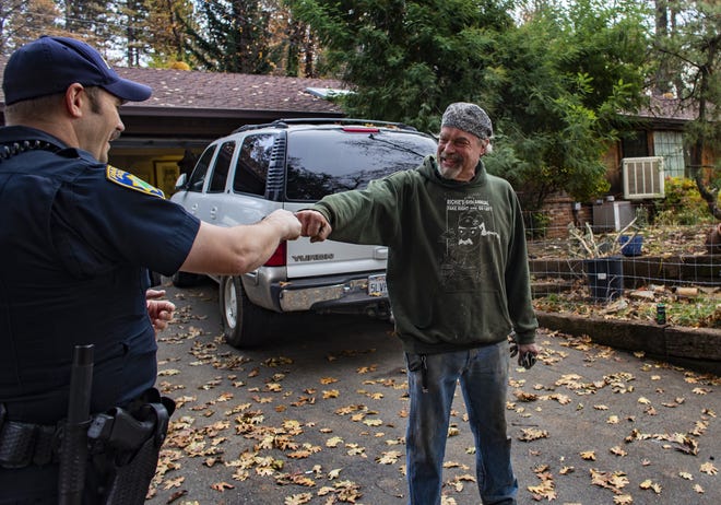Paradise Police Officer Perry Walters checks on the welfare of resident Brad Weldon, who refused to leave his property during the fire, on Nov. 26, 2018 in Paradise, Calif. Weldon is grateful that the police bring him and his 90-year-old mother supplies, but he questions why he isn't allowed to leave to get supplies himself and return. Once he leaves, he won't be allowed back. Most of the homes around Weldon's burned to the ground, though Weldon's was unscathed. (Gina Ferazzi/Los AngelesTimes/TNS)