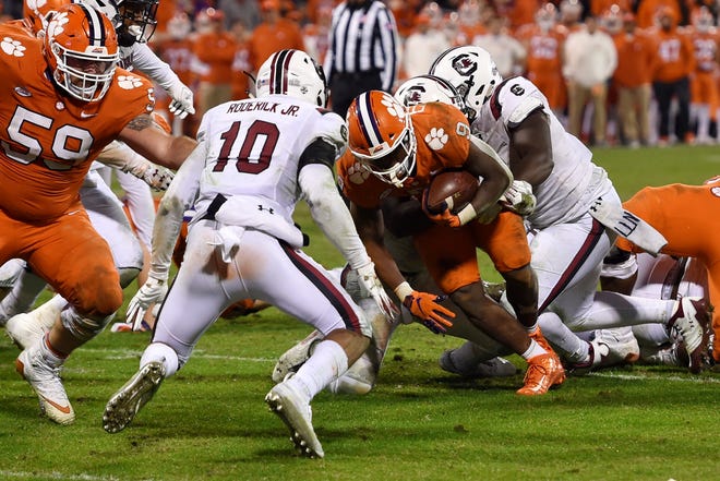 Clemson's Travis Etienne scores a touchdown while defended by South Carolina's R.J. Roderick during the second half of an NCAA college football game Saturday, Nov. 24, 2018, in Clemson, S.C. Clemson won 56-35. (AP Photo/Richard Shiro)