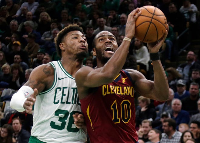 Celtics guard Marcus Smart, left, who got the starting nod, shadows the Cavaliers' Alec Burks as he drives to the basket in Friday's game at TD Garden.