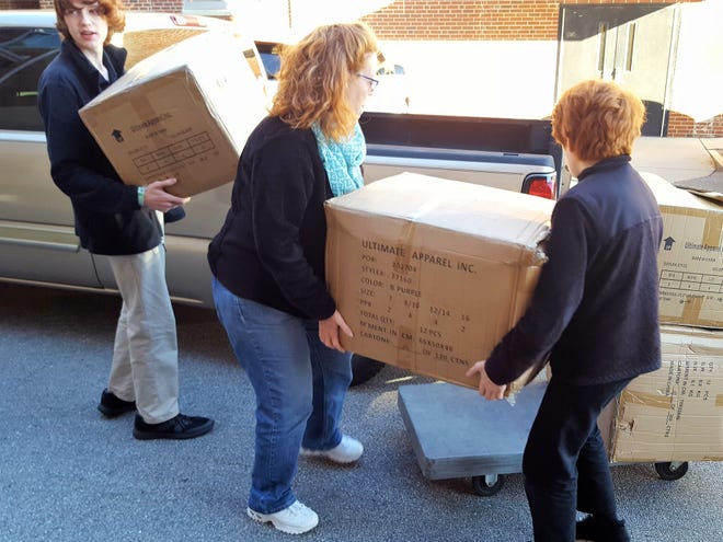 Volunteers unload boxes of coats. The coats were collected by the Knights of Columbus as part of the "Coats for Kids" project which will benefit Cleveland County children. [SPECIAL TO THE STAR]