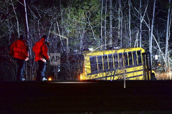 Emergency medical crew members respond to an accident involving a school bus that crashed into the woods off Route 24 South in Berkley, Mass., on Saturday night. The group was returning back to Tiverton, R.I., from LaSalette Shrine in North Attleboro, Mass. [MARC VASCONCELLOS/THE BROCKTON ENTERPRISE VIA AP]