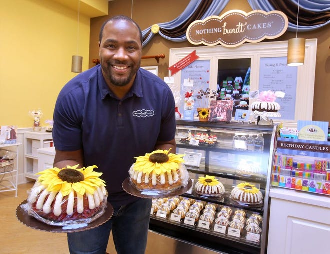 Nothing Bundt Cakes owner Kenny Peterson shows off some treats at his business in Jackson Township just outside Canton. The Canton native played defensive end for the Ohio State Buckeyes, the Green Bay Packers and the Denver Broncos. [Scott Heckel/Canton Repository]
