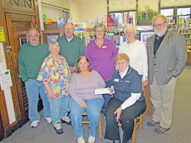 Sue Hart, Friends of the Bronson Library treasurer, received a matching grant of $616 from Diana Elkins of Modern Woodman. Standing are library friends Hugh Law, Fran Fletcher, Jim Shafer, Librarian Lynnell Eash, Gayle Clover and Steve Wilson, library staff.