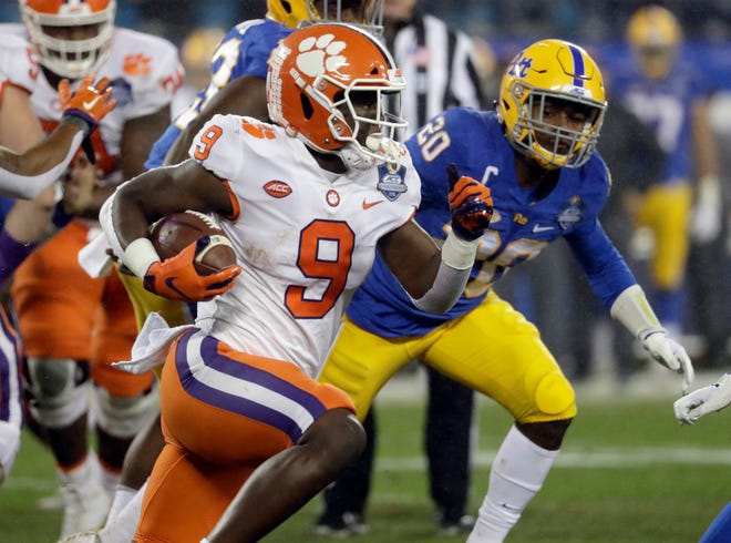 Clemson's Travis Etienne (9) runs past Pittsburgh's Dennis Briggs (20) in the first half of the Atlantic Coast Conference championship NCAA college football game in Charlotte, N.C., Saturday, Dec. 1, 2018. (AP Photo/Chuck Burton)