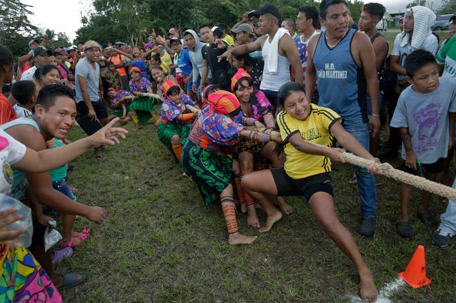 In this Nov. 25, 2018 photo, Guna indigenous women compete in the tug-of-war during the second edition of the Panamanian indigenous games in Piriati, Panama. Indigenous people from the four most important ethnic groups in Panama participated for two days to select the athletes that will represent Panama in the upcoming World Indigenous Peoples Games. (AP Photo/Arnulfo Franco)
